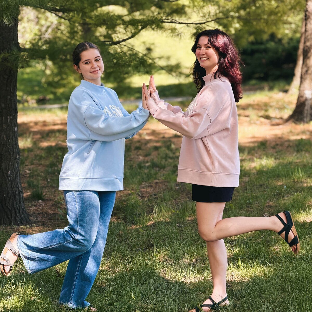 A student wearing League Women's Iowa State Dusty Pink Mock Neck Crew Sweatshirt with another student wearing the matching blue version